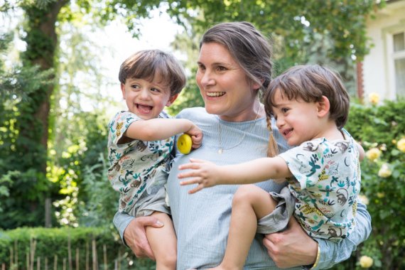 Mutter mit zwei kleinen Kindern auf dem Arm