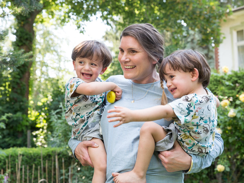 Mutter mit zwei kleinen Kindern auf dem Arm